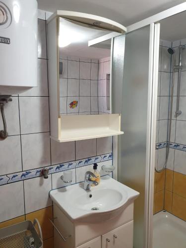 a bathroom with a sink and a mirror at Apartmani Štulec in Preko