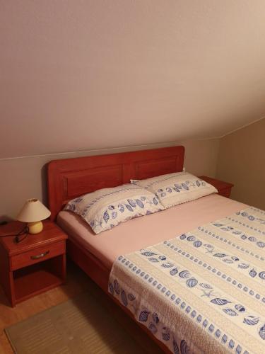 a bedroom with a bed and a table with a lamp at Apartmani Štulec in Preko