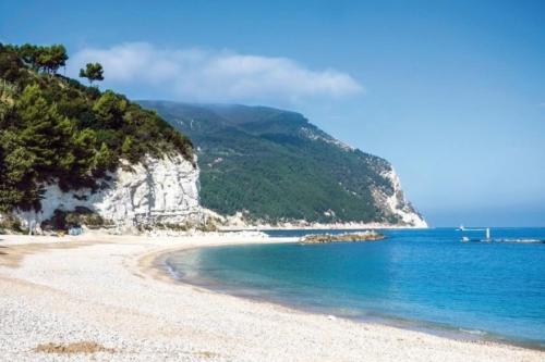 a beach with blue water and a mountain at Affittacamere Flli Rossi in Tornasano