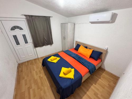 a bedroom with a bed with yellow and orange pillows at Mon in Bar