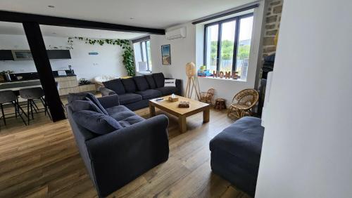 un salon avec deux canapés et une table dans l'établissement Maison calme à proximité des plages, à Penmarcʼh