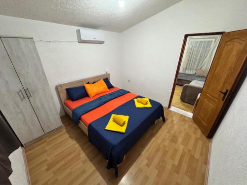 a bedroom with a bed with yellow and orange pillows at Mon in Bar