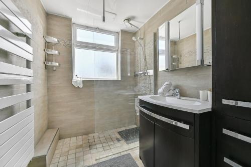 une salle de bain avec un lavabo et une douche dans l'établissement La belle escale entre Paris et Disney, à Le Perreux-Sur-Marne