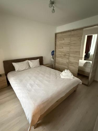 a large bed in a room with a mirror at Bella Home, the place to stay in Lugoj in Lugoj