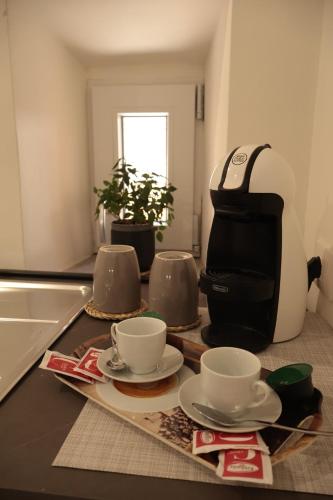 a counter with three cups and a coffee maker at Alloggio turistico Il punto di vista in Tuscania