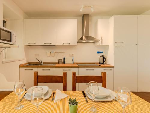a kitchen with a table with plates and glasses on it at Apartment Persico by Interhome in Consiglio di Rumo