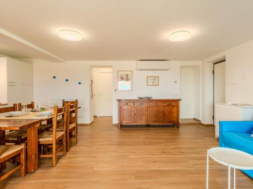 a dining room with a table and a blue couch at Apartment Persico by Interhome in Consiglio di Rumo