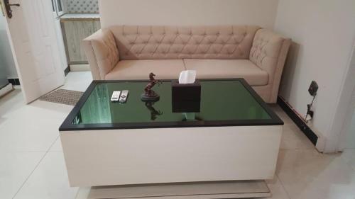 a living room with a couch and a glass table at ALAF Lodges in Dargai