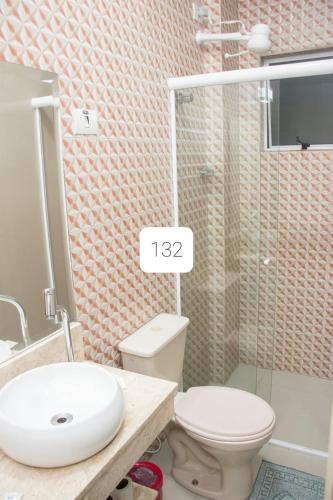 a bathroom with a toilet and a sink and a shower at Hotel Morada do Mar in Guarujá