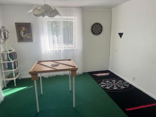 a room with a table and a dart board on the floor at Hine Bakke Bed And Breakfast in Rudkøbing