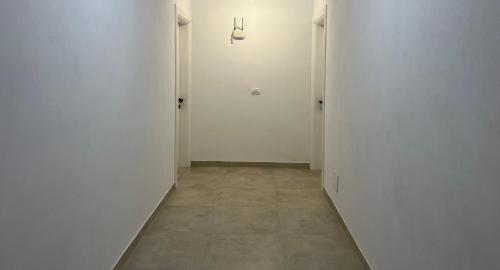 an empty hallway with white walls and a tile floor at 3rd Floor Mali i Robit Apartments in Golem