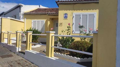 a yellow house with a fence in front of it at House of Roses in Ponta Delgada