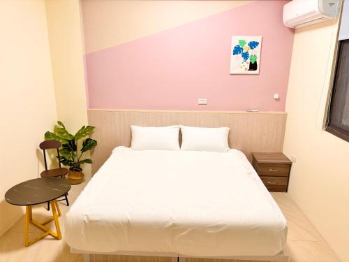 a bedroom with a white bed and a purple wall at 玉里步道民宿 in Yuli