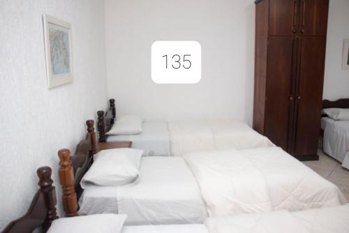 a group of four beds in a room at Hotel Morada do Mar in Guarujá
