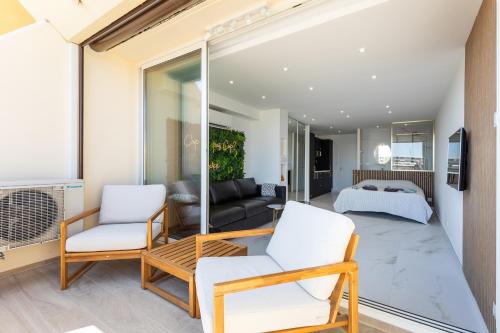 ein Wohnzimmer mit zwei Stühlen und einer Couch in der Unterkunft Naturiste Cap d'Agde Héliopolis Eden Suite in Cap d'Agde