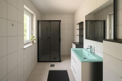 ein Bad mit einer Dusche und einem grünen Waschbecken in der Unterkunft Holiday Home Nido Verde in Santalezi