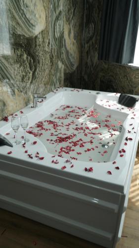 a bath tub covered in red roses with wine glasses at Dual Hotel Spa in Istanbul