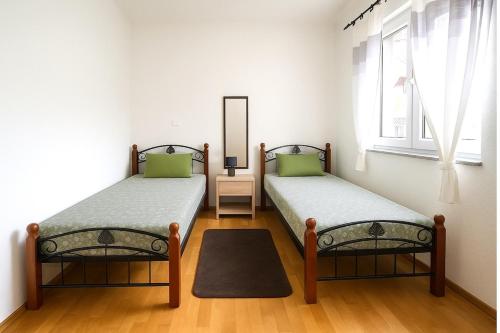 2 Einzelbetten in einem Zimmer mit Spiegel in der Unterkunft Holiday Home Nido Verde in Santalezi