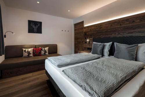 a bedroom with a large bed and a couch at Chalet Bel Plan in Ortisei