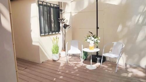 two chairs and a table with flowers on a balcony at Tonight Homestay West Nanjing Road Shanghai in Shanghai
