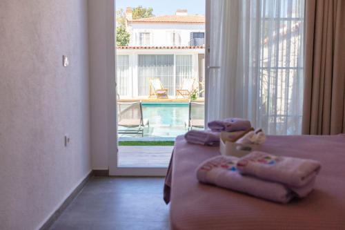 ein Schlafzimmer mit einem Bett mit Handtüchern und einem Fenster in der Unterkunft Noesta Alaçatı in Alacati
