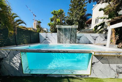 a pool in a backyard with a fountain at Luxury Villa 6BR with Swimming Pool by Beach - Villa Costa in Rishon LeẔiyyon
