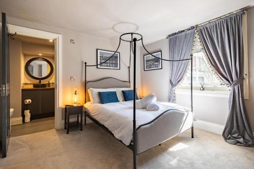 a bedroom with a canopy bed with blue pillows at The Boat House Luxury Apartments Scarborough in Scarborough