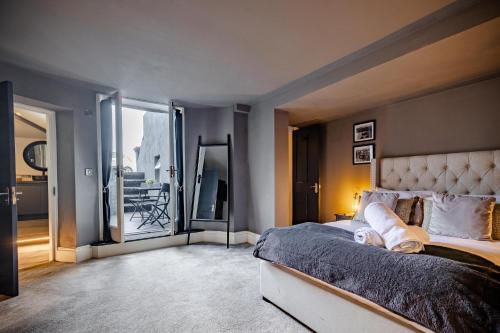 a bedroom with a large bed and a balcony at The Boat House Luxury Apartments Scarborough in Scarborough