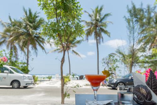 a drink on a table with palm trees in the background at h78 in Hulhumale