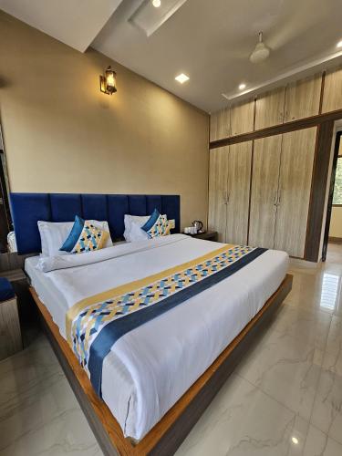 a large bed with a blue headboard in a bedroom at The Sky Comfort Hotel Brahm Sambandh in Nāthdwāra