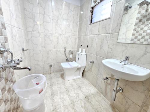a bathroom with a toilet and a sink at The Sky Comfort Hotel Brahm Sambandh in Nāthdwāra