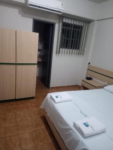 a room with a bed and a kitchen with a window at Hotel Real in Petrolina