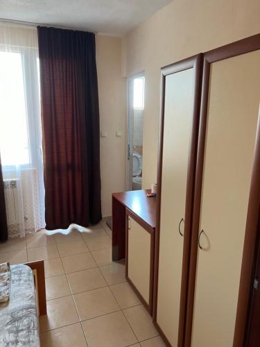 a hotel room with a desk and a mirror at Milchevi Guesthouse in Sozopol