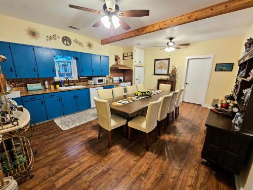 a kitchen and dining room with blue cabinets and a table at Historic Farmhouse - Tranquil Nature Escape in Hondo