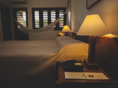 a bedroom with a hammock bed and a table with a lamp at Hotel Fazenda Portal de Gravatá in Gravatá