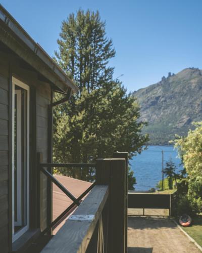 a porch of a house with a view of the water at INDÓMITO HOSTEL in San Carlos de Bariloche