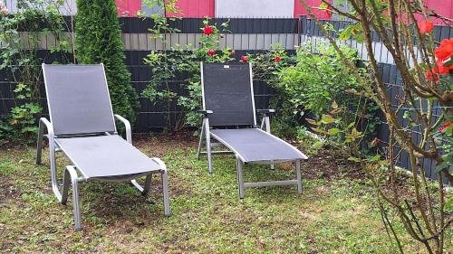 two chairs sitting in the grass in a garden at Ferienwohnung nähe Red Bull Ring mit eingezäunten Garten in Judenburg
