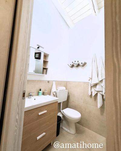 a bathroom with a toilet and a sink at Amati home in Floridia