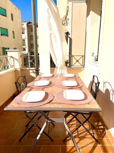 a table on a balcony with a table and chairs at Alghero Heart in Alghero