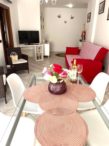 a table with a vase of flowers on it in a living room at Alghero Heart in Alghero