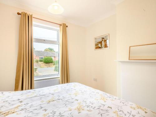 a bedroom with a bed and a window at Manager's Cottage in Loddon