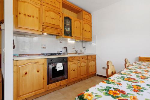 a small kitchen with wooden cabinets and a table at Casa Antonia in Brentonico