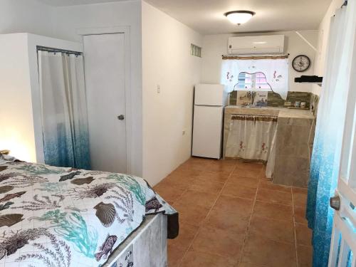 a bedroom with a bed and a kitchen at Peaceful Beach Studio in the Heart of Puntas in Rincon