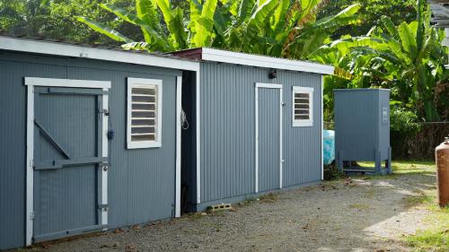 a gray shed with a door and a gate at Peaceful Beach Studio in the Heart of Puntas in Rincon
