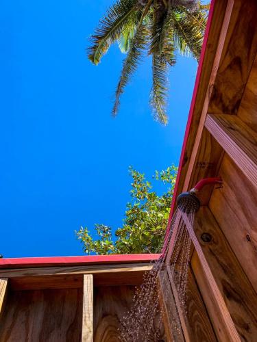 a hammock on the side of a wooden building with a palm tree at Peaceful Beach Studio in the Heart of Puntas in Rincon