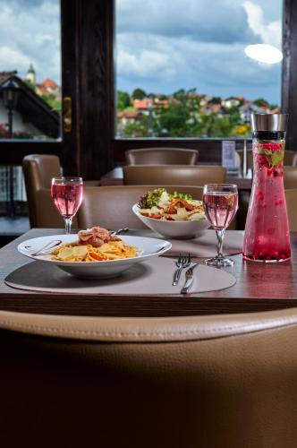 a table with two plates of food and wine glasses at LuCA Hotel in Bodenmais