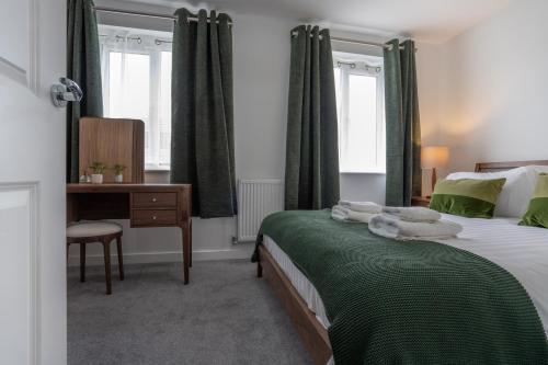 a bedroom with a bed and a desk and windows at Peak Avenue Retreat in Chesterfield