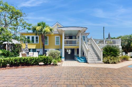 a yellow house with a staircase in front of it at Georgianne Suite Five in Tybee Island