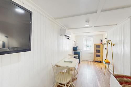 a room with a table and a tv on a wall at Georgianne Suite Five in Tybee Island