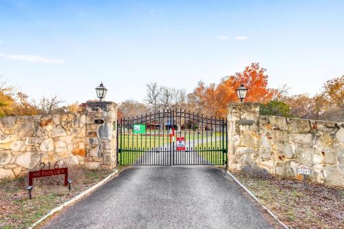 an entrance to a gate with a stone wall at Mill Lodge in Wimberley